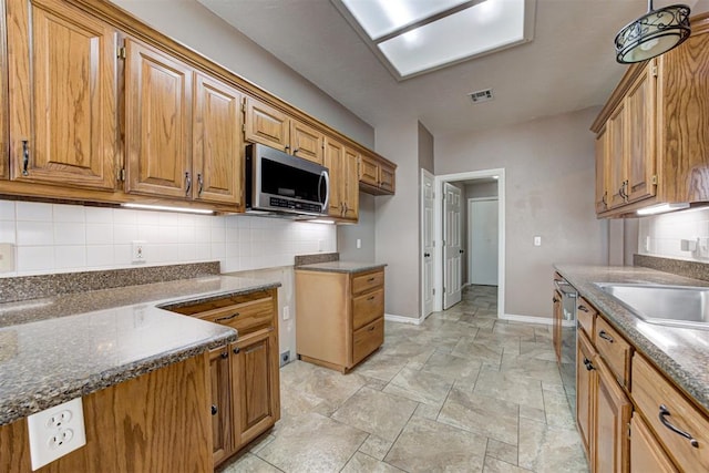 kitchen featuring appliances with stainless steel finishes, visible vents, backsplash, and baseboards