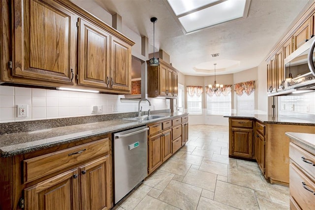 kitchen featuring an inviting chandelier, tasteful backsplash, appliances with stainless steel finishes, and a sink