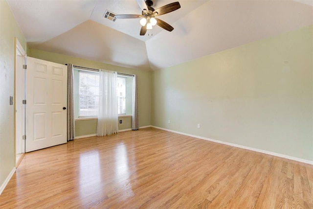 interior space featuring vaulted ceiling, light wood finished floors, visible vents, and baseboards