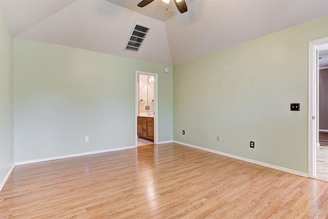 unfurnished room with lofted ceiling, visible vents, light wood-style flooring, and baseboards