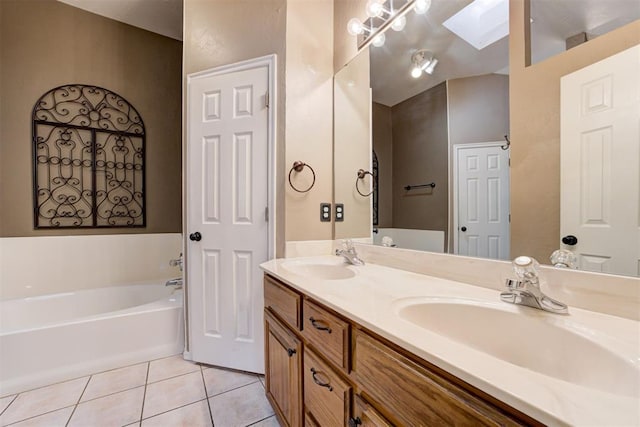 full bathroom featuring a skylight, tile patterned flooring, a sink, and a bath