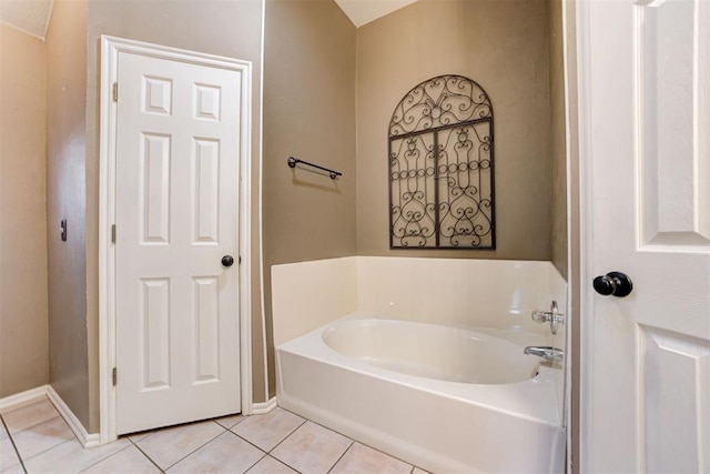 bathroom with baseboards, a bath, and tile patterned floors