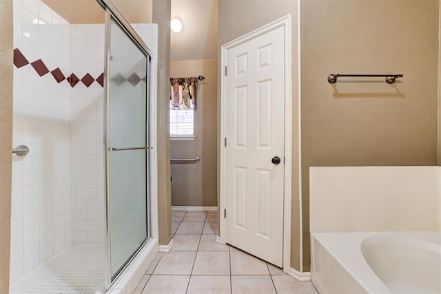 full bathroom with a stall shower, tile patterned flooring, and a bath