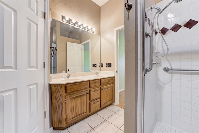 bathroom featuring a sink, double vanity, tile patterned flooring, and a shower stall