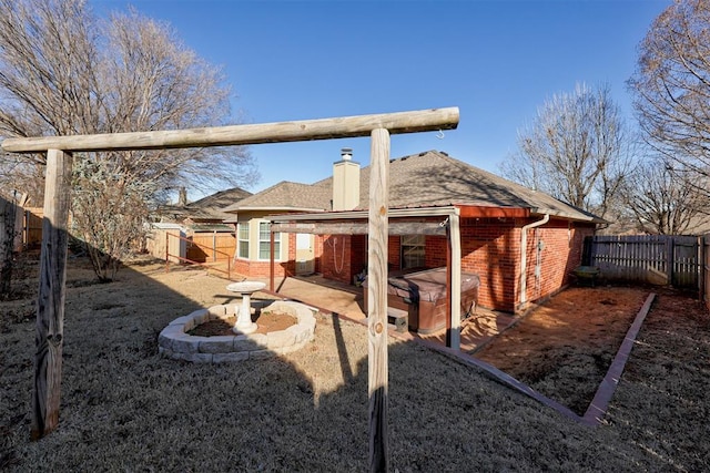 exterior space featuring a hot tub, a fenced backyard, and a patio