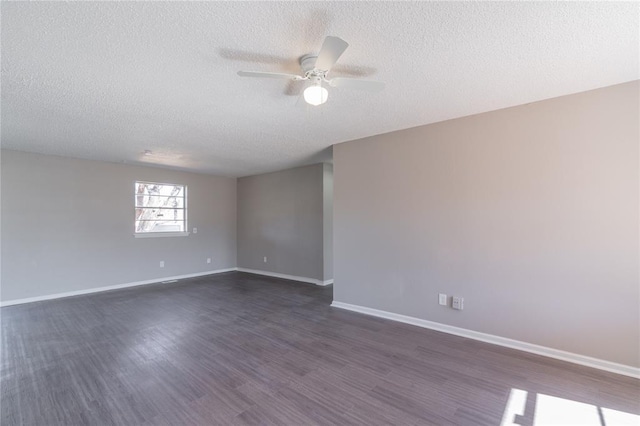 empty room with ceiling fan, baseboards, a textured ceiling, and dark wood finished floors