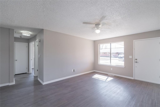 interior space featuring visible vents, baseboards, a textured ceiling, a ceiling fan, and dark wood-style flooring