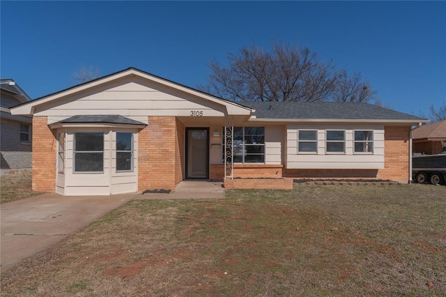 ranch-style house featuring brick siding and a front yard