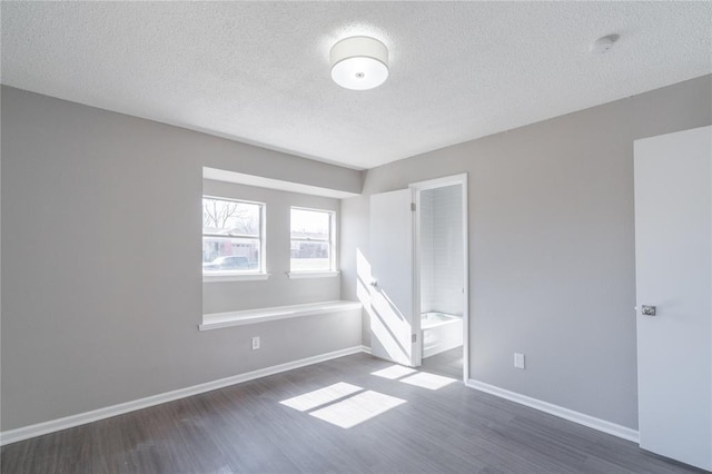 unfurnished bedroom with baseboards, a textured ceiling, and wood finished floors