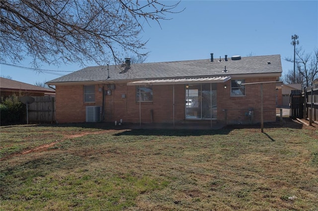 back of house featuring brick siding, fence, and a yard
