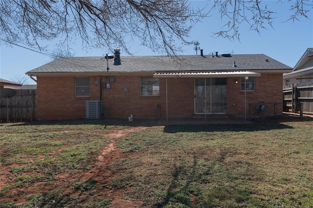 rear view of house with central AC unit, a patio area, brick siding, fence, and a yard
