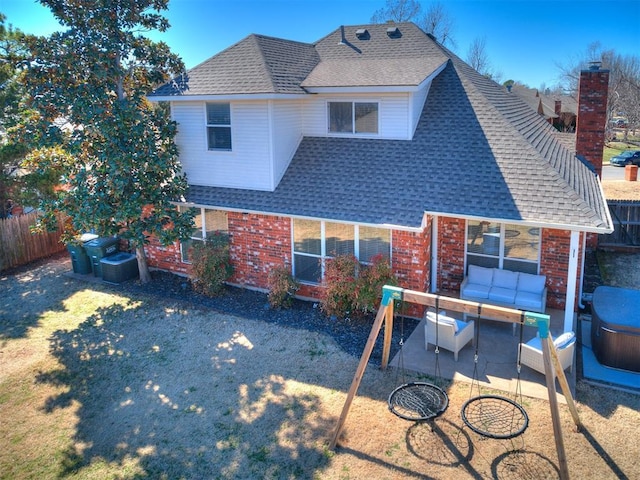 back of property with a patio, an outdoor hangout area, roof with shingles, fence, and brick siding