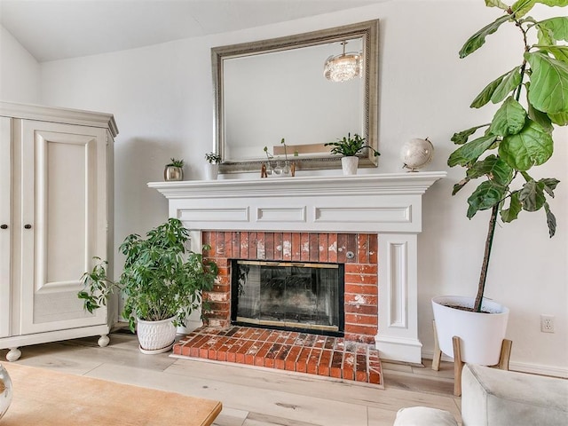 room details featuring a brick fireplace and wood finished floors