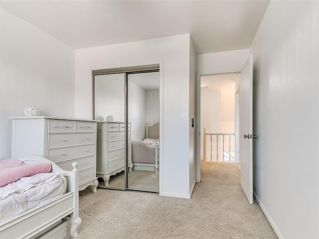 bedroom featuring carpet, baseboards, and a closet