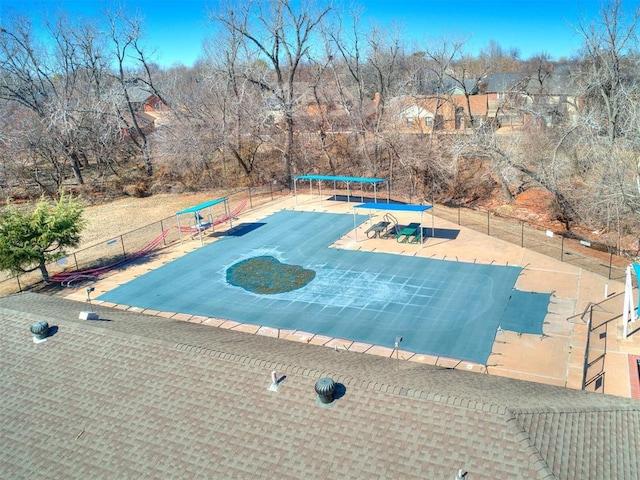 view of swimming pool with a trampoline and fence