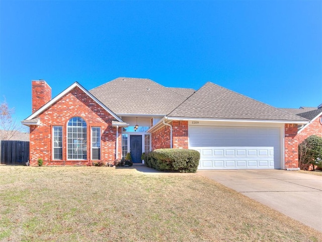 single story home featuring brick siding, a chimney, a garage, driveway, and a front lawn