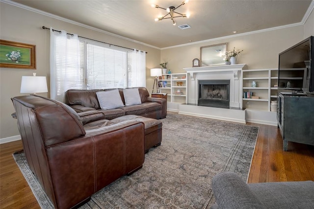 living room featuring visible vents, a fireplace with raised hearth, wood finished floors, and ornamental molding