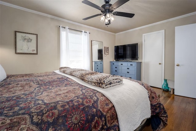 bedroom featuring ornamental molding, wood finished floors, and a ceiling fan