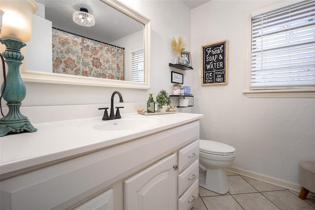 bathroom featuring toilet, tile patterned flooring, baseboards, and vanity