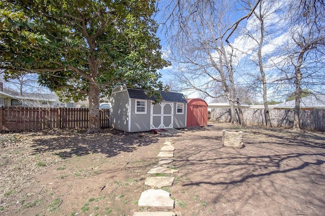 view of yard with a fenced backyard, a storage unit, and an outdoor structure