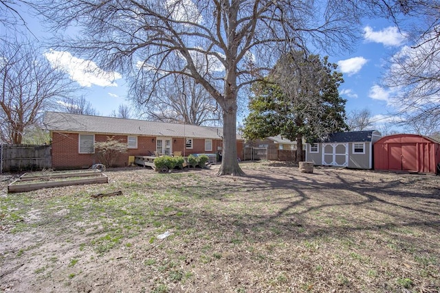 view of yard featuring a storage shed, fence, and an outdoor structure