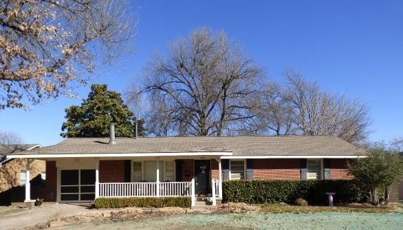 single story home featuring a garage, covered porch, brick siding, and driveway