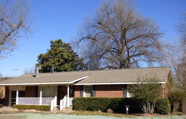 single story home featuring covered porch and brick siding