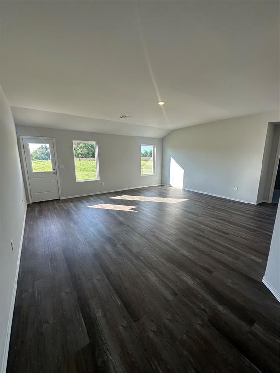 43068 Wagon Trl, Shawnee, OK 74804 - unfurnished living room with dark wood-style flooring and vaulted ceiling
