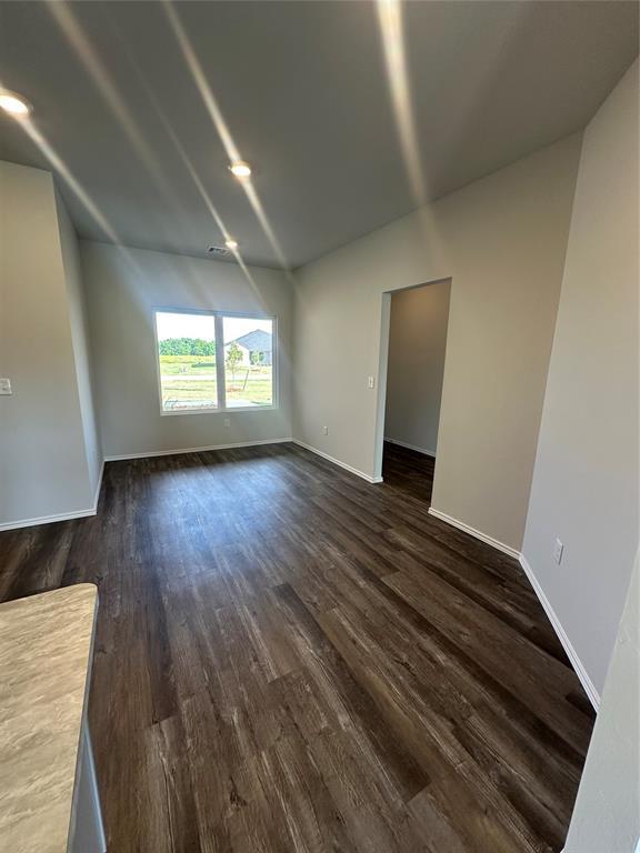 43068 Wagon Trl, Shawnee, OK 74804 - spare room with lofted ceiling and dark wood finished floors