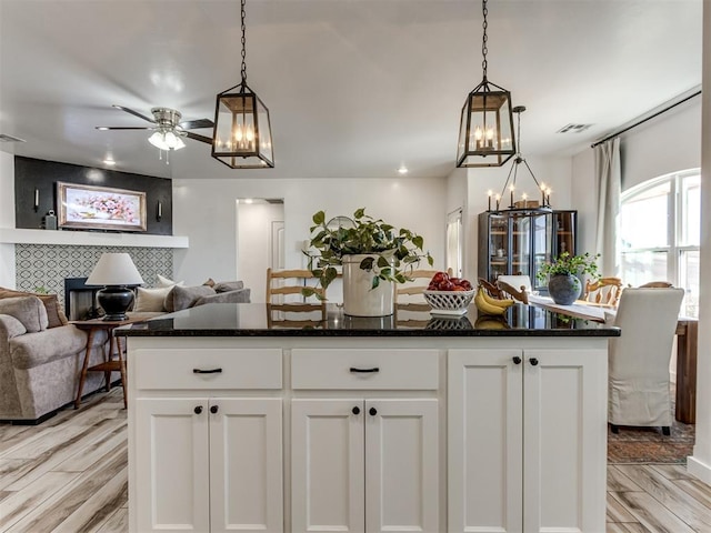 kitchen with light wood-type flooring, visible vents, and white cabinets