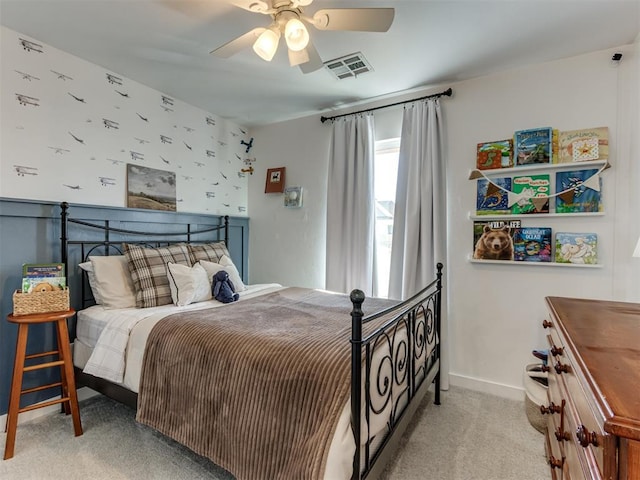 carpeted bedroom with baseboards, visible vents, and a ceiling fan