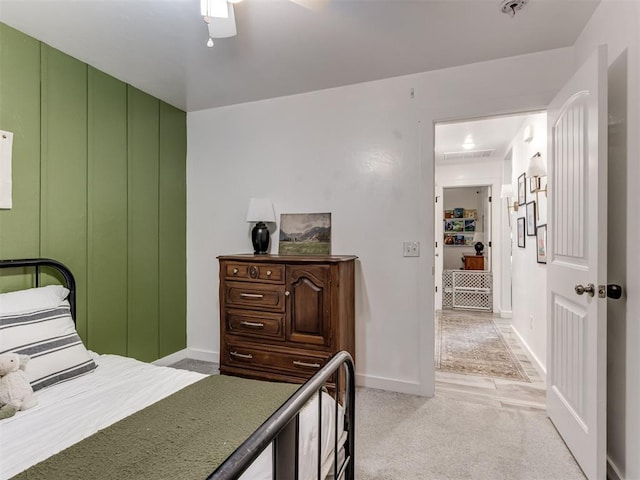 bedroom featuring a ceiling fan, light colored carpet, and baseboards