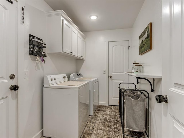 clothes washing area with cabinet space, baseboards, and washing machine and clothes dryer