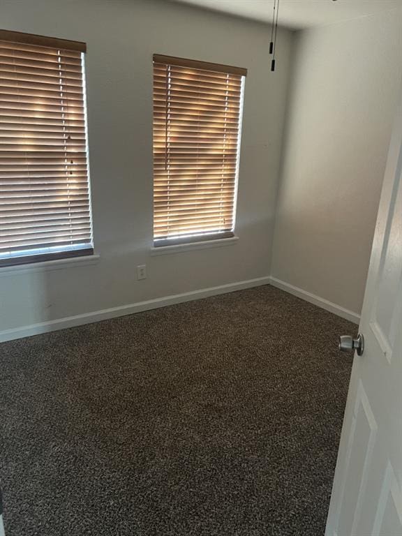 unfurnished room with carpet and baseboards