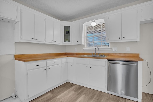 kitchen featuring dishwasher, a sink, white cabinets, and light wood-style floors