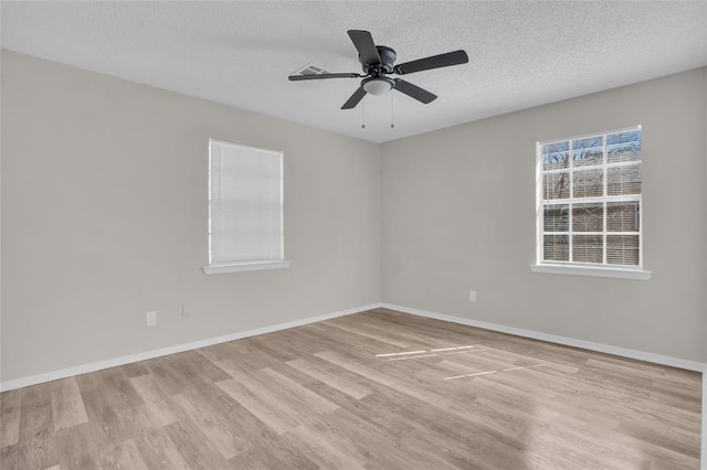 unfurnished room with visible vents, baseboards, ceiling fan, a textured ceiling, and light wood-style floors