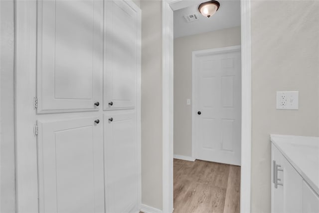 bathroom featuring baseboards, visible vents, wood finished floors, and vanity