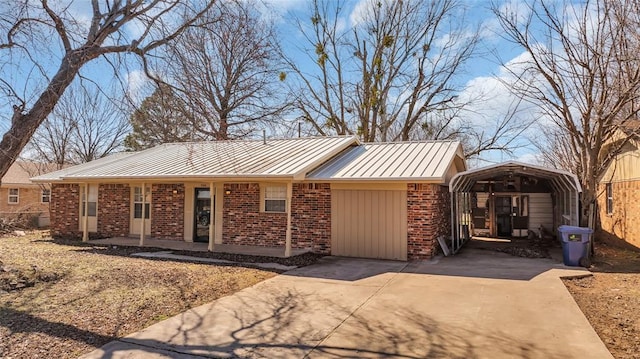 ranch-style house featuring brick siding, concrete driveway, covered porch, a standing seam roof, and a detached carport