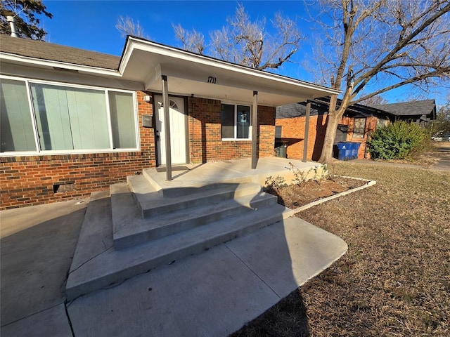 property entrance featuring brick siding