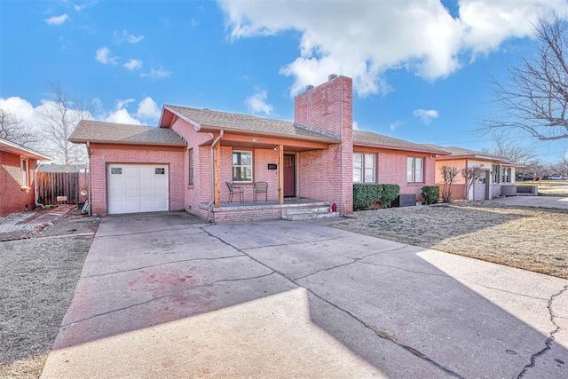 ranch-style home featuring covered porch, brick siding, a chimney, and concrete driveway