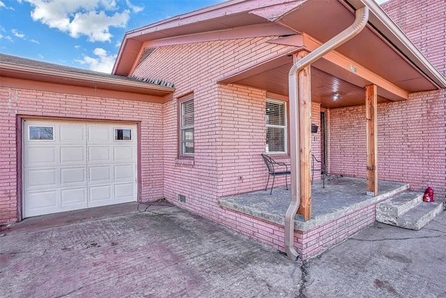 exterior space featuring driveway, brick siding, and crawl space