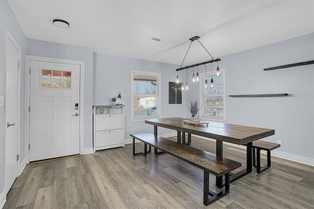 dining room featuring visible vents, baseboards, and wood finished floors