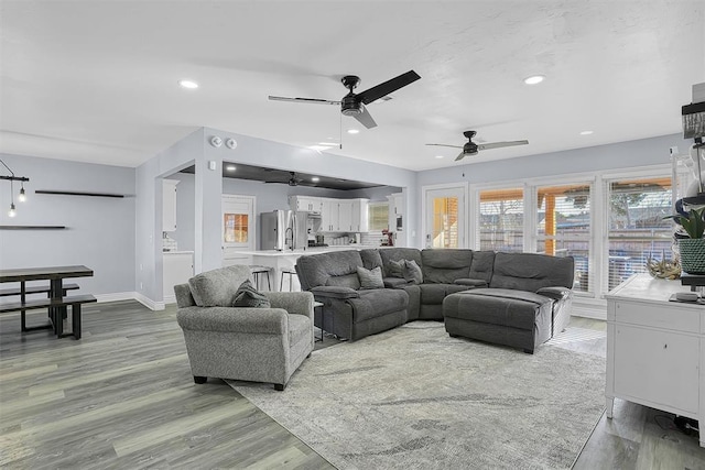 living room with recessed lighting, ceiling fan, baseboards, and wood finished floors