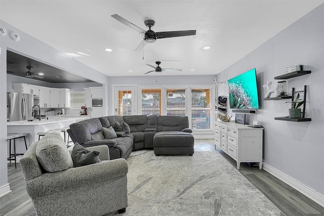 living room with baseboards, wood finished floors, and recessed lighting