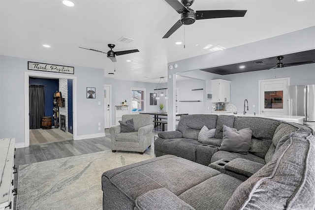 living room with a ceiling fan, recessed lighting, visible vents, and light wood-style floors