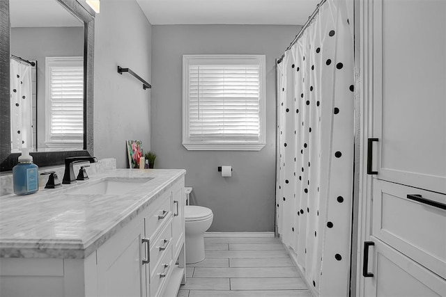 full bath featuring toilet, baseboards, and vanity