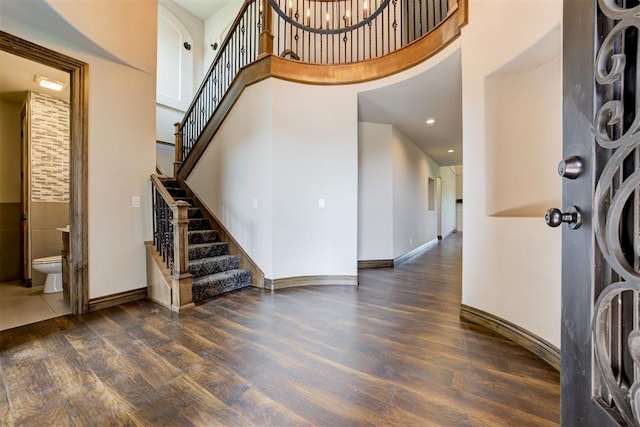 entryway with a high ceiling, wood finished floors, and baseboards