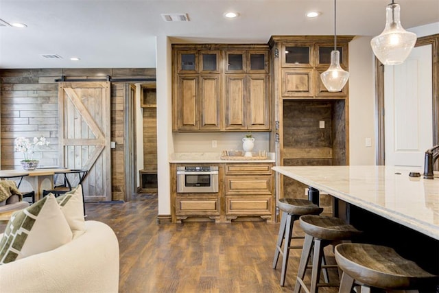 kitchen with visible vents, a barn door, dark wood finished floors, and oven