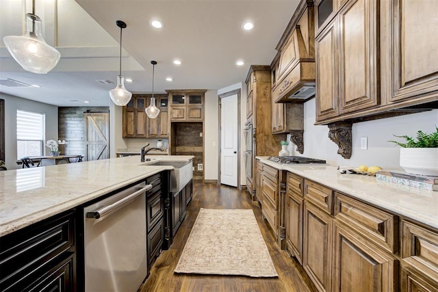 kitchen with stainless steel appliances, recessed lighting, a sink, and a barn door