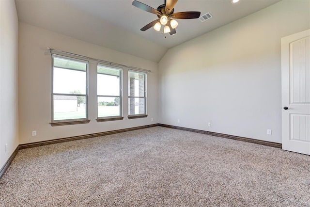 carpeted spare room with visible vents, vaulted ceiling, baseboards, and ceiling fan